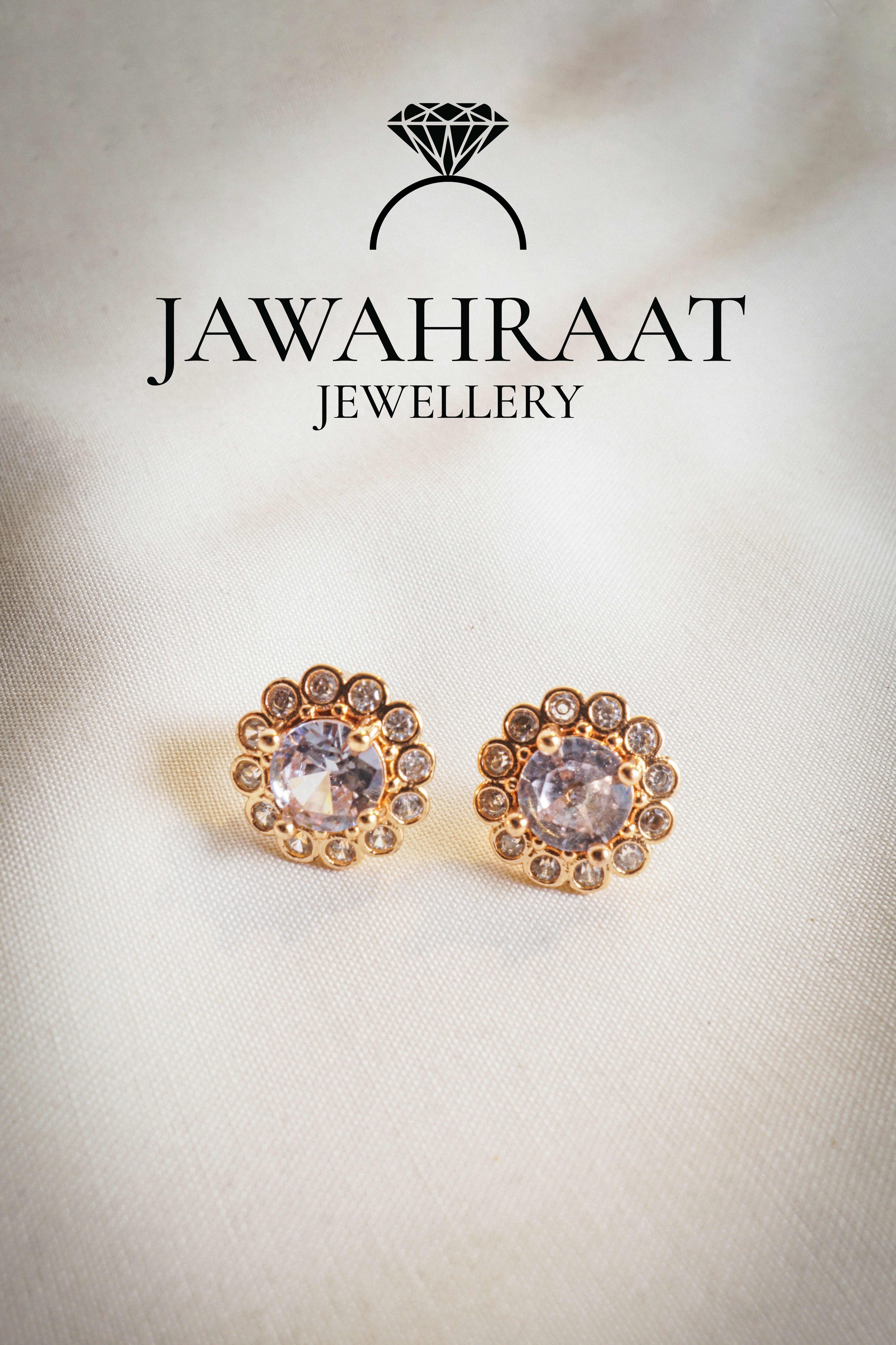 Close-up of gold-plated floral stud earrings featuring shimmering crystals in a delicate pattern