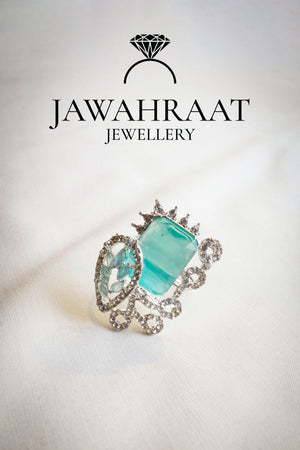 Front view of the Elara ring in aqua teal by Jawahraat Jewellery – silver-tone adjustable ring with rectangular crystal, pave stones, and scrollwork detailing.