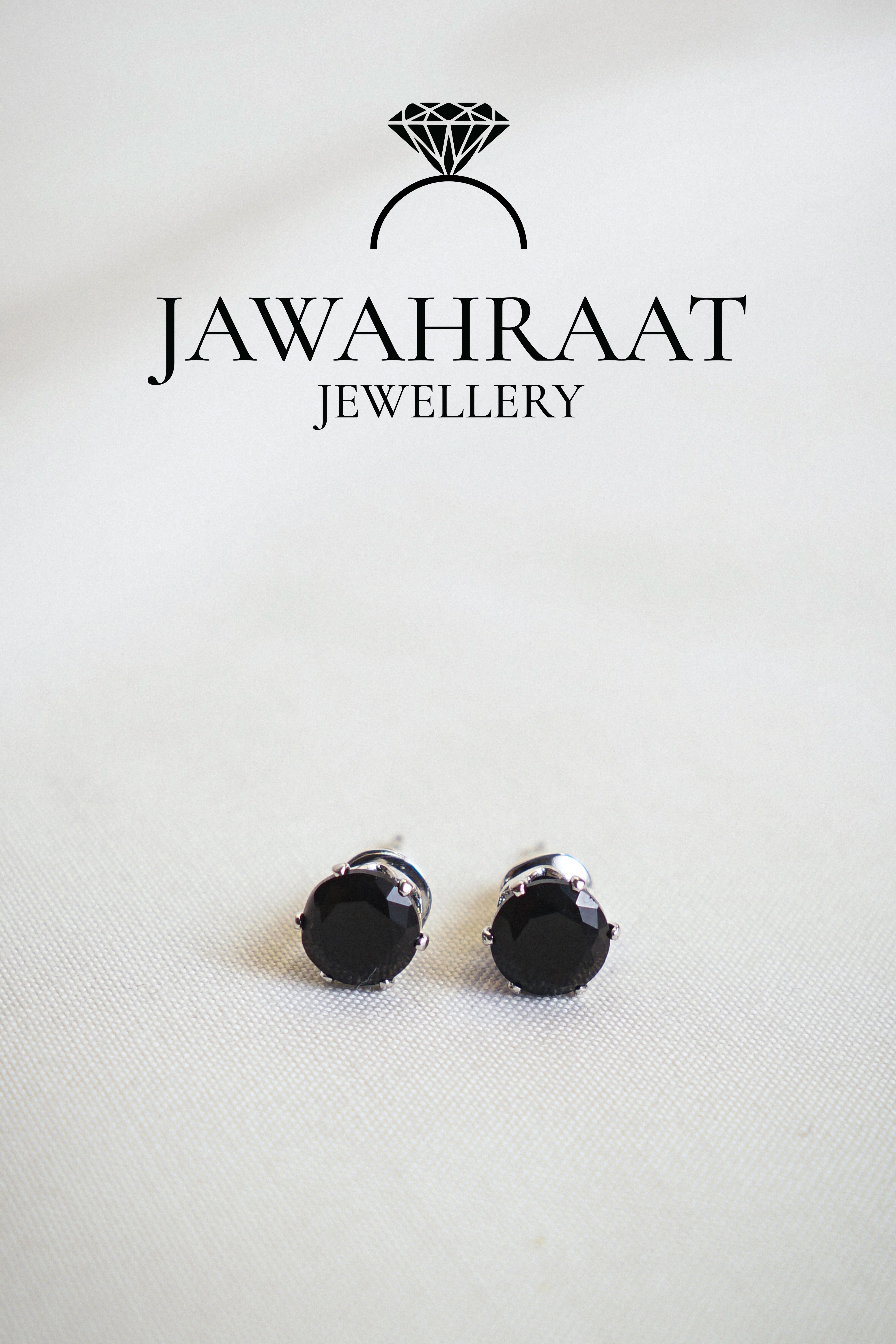 Close-up of matching black teardrop stud earrings by Jawahraat Jewellery, featuring silver-toned edges and shimmering crystal details for a refined, elegant finish.