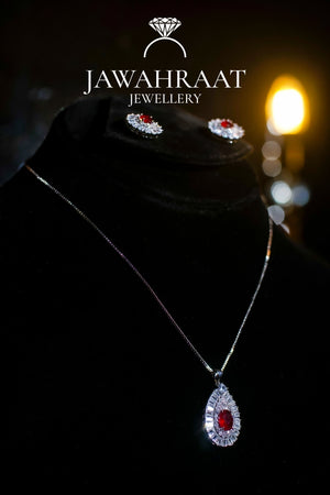Silver-toned necklace with deep red teardrop pendant and sparkling stones, traditional and elegant