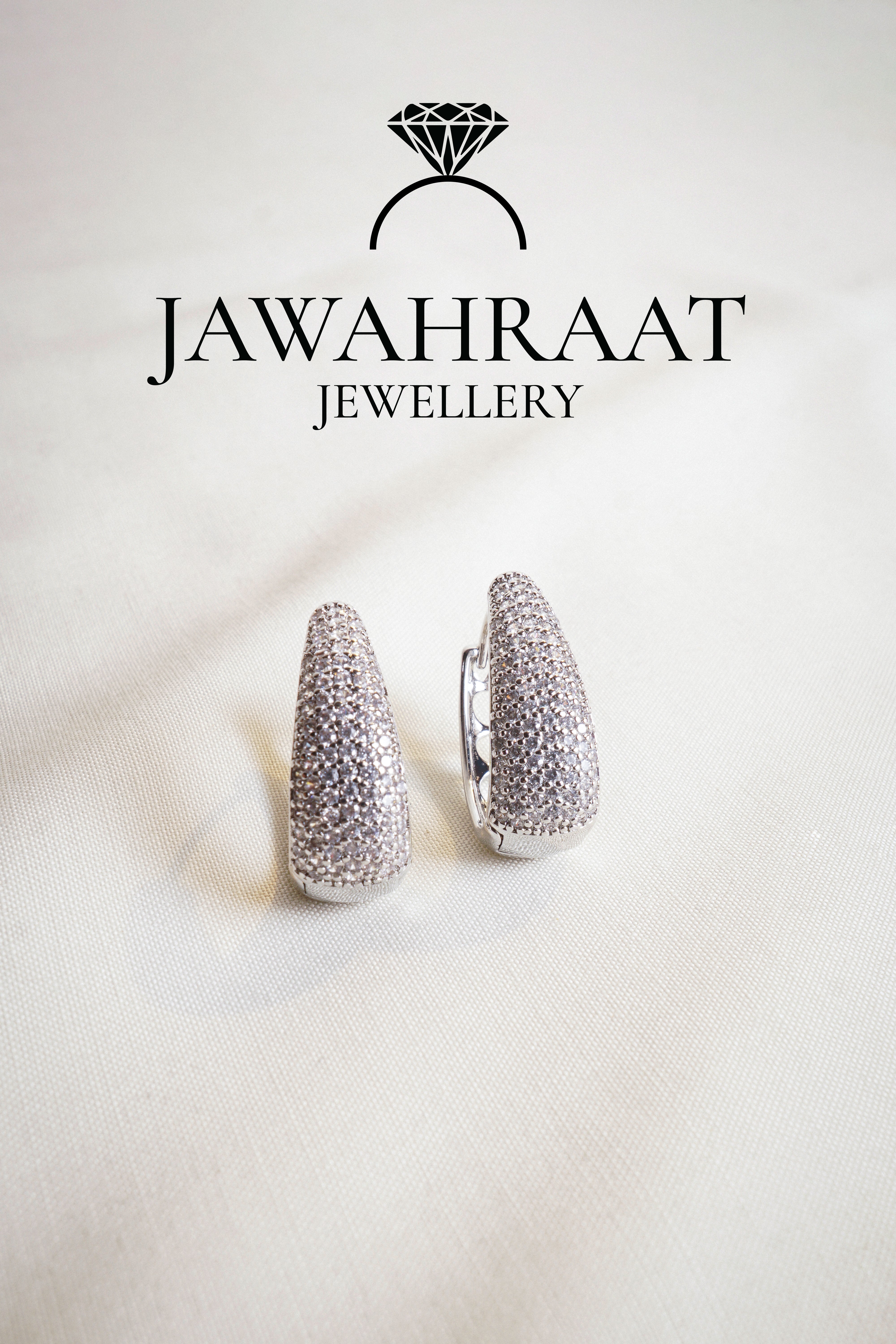 Silver-tone crystal huggie earrings featuring pavé detailing from Jawahraat Jewellery