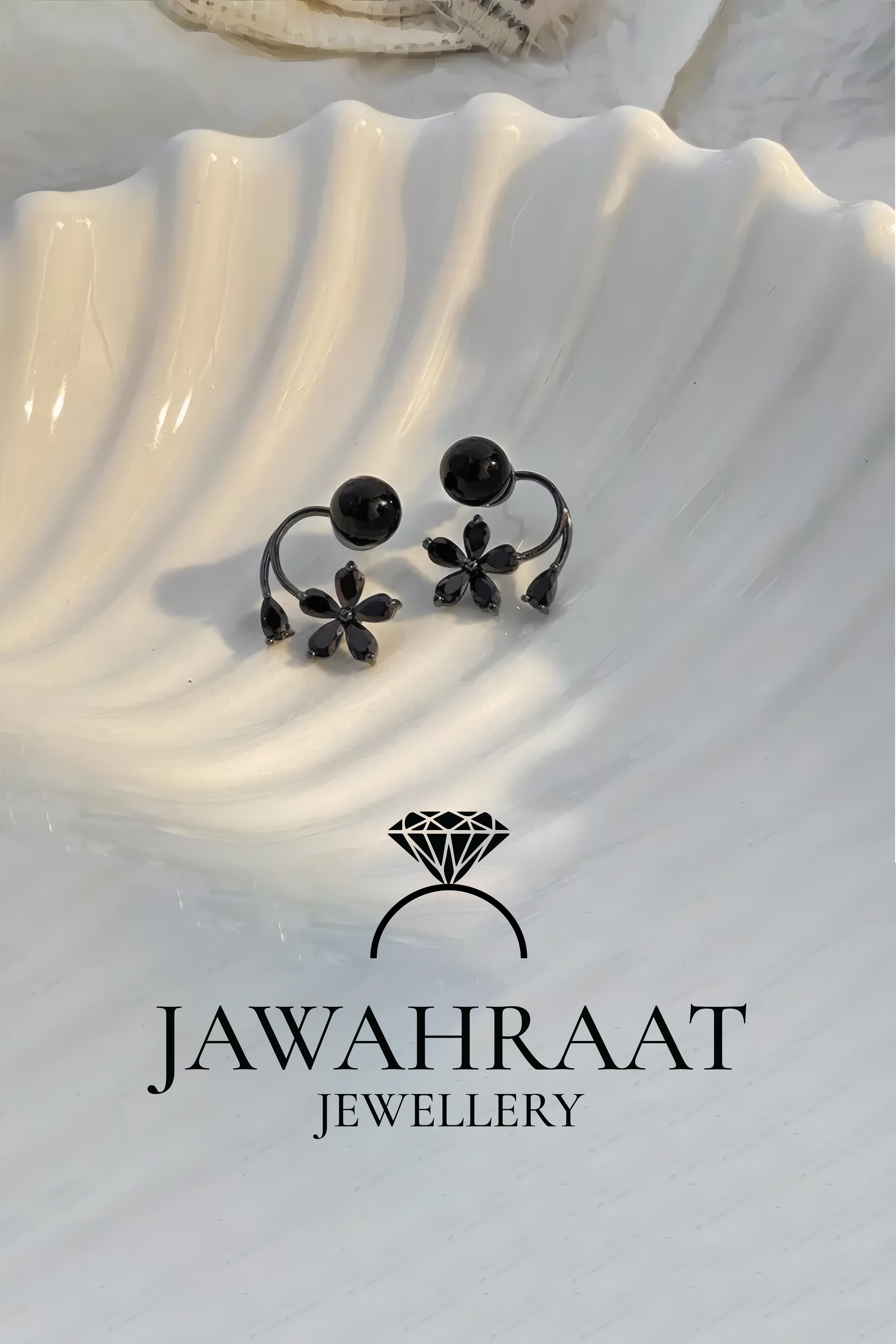 Black flower drop and pearl stud earrings set displayed on satin background, premium artificial jewellery by Jawahraat Jewellery