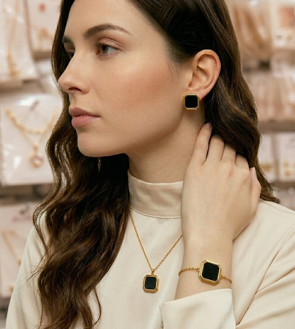 Woman wearing black geometric gold plated fashion jewelry set with necklace bracelet and earrings