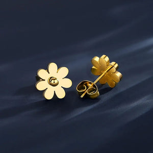 Gold daisy flower stud earrings close-up on dark background