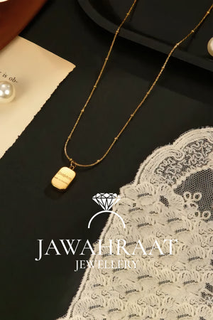 Minimalist gold plated bar pendant necklace displayed on satin fabric from Jawahraat Jewellery artificial jewelry brand