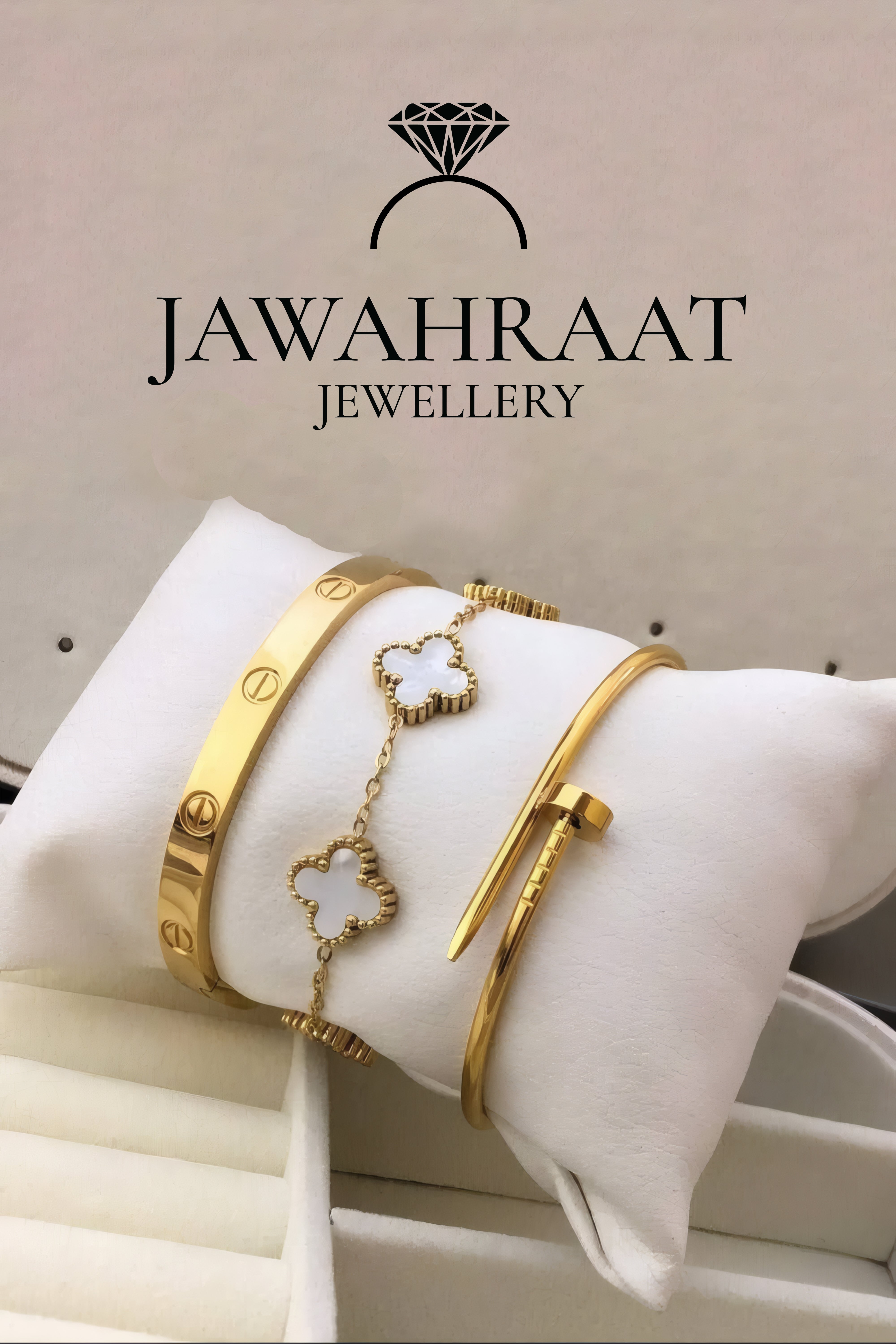 Set of 3 gold-tone bracelets – Love bangle, white clover charm, and nail bangle displayed on cushion from Jawahraat Jewellery artificial jewellery collection
