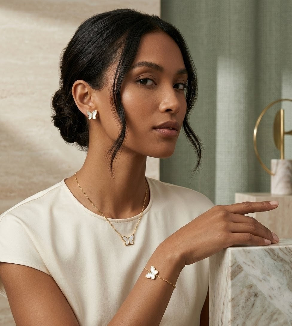 Woman wearing mother of pearl butterfly jewelry set with gold necklace earrings and bracelet