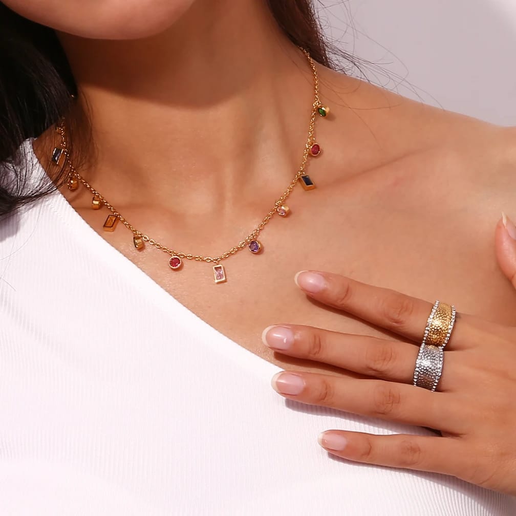 Woman wearing gold plated multi color charm necklace with rainbow crystals