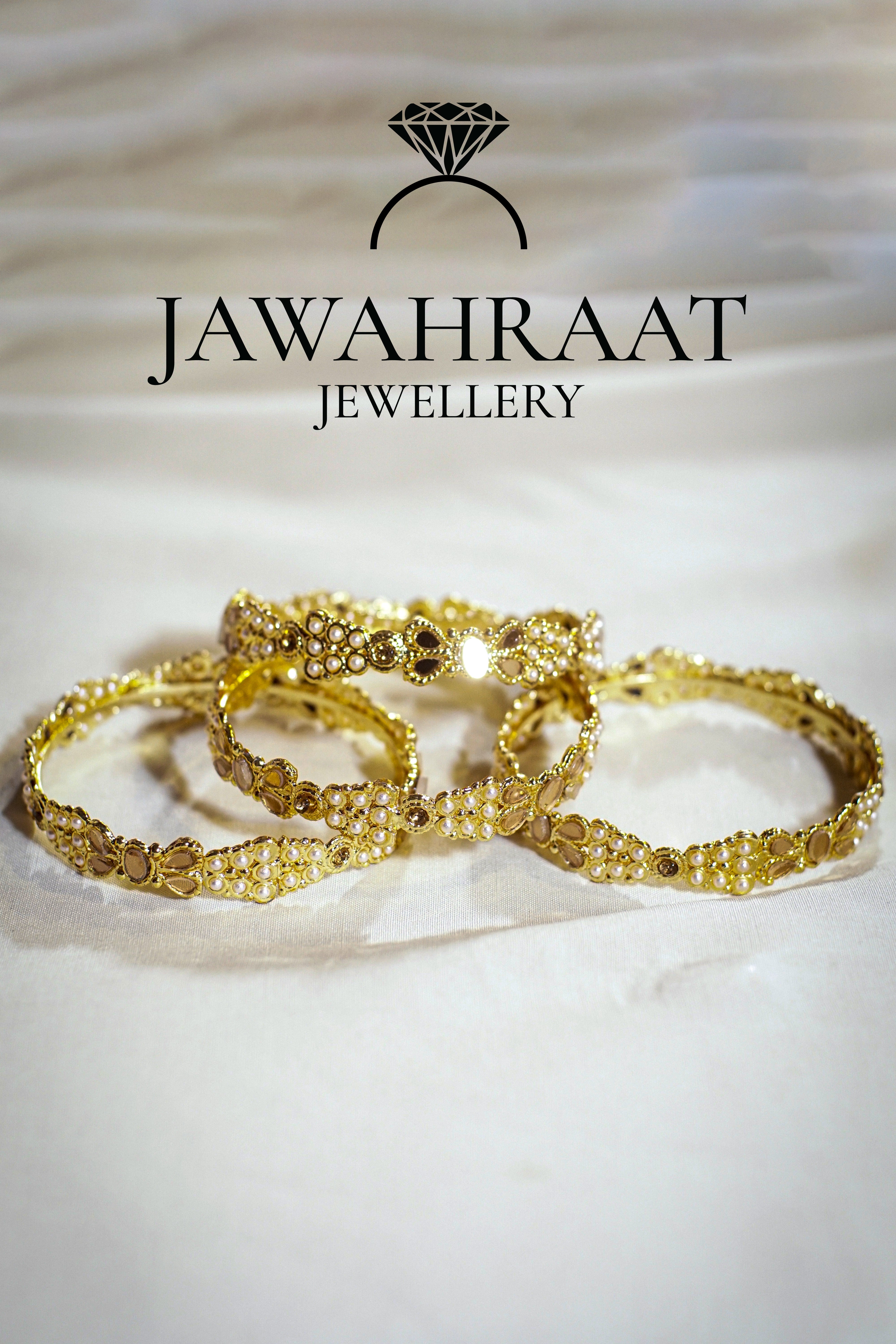 Close-up of gold-tone bangles with pearl-like beads and sparkling stones – elegant traditional bangle set by Jawahraat
