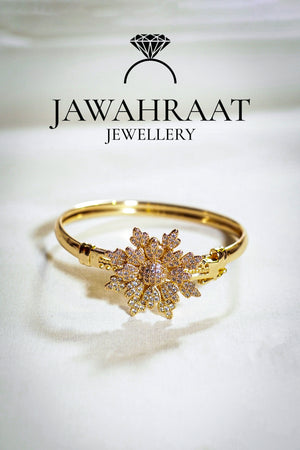 Intricate gold-toned bangle with floral detailing and white stones – festive wear accessory