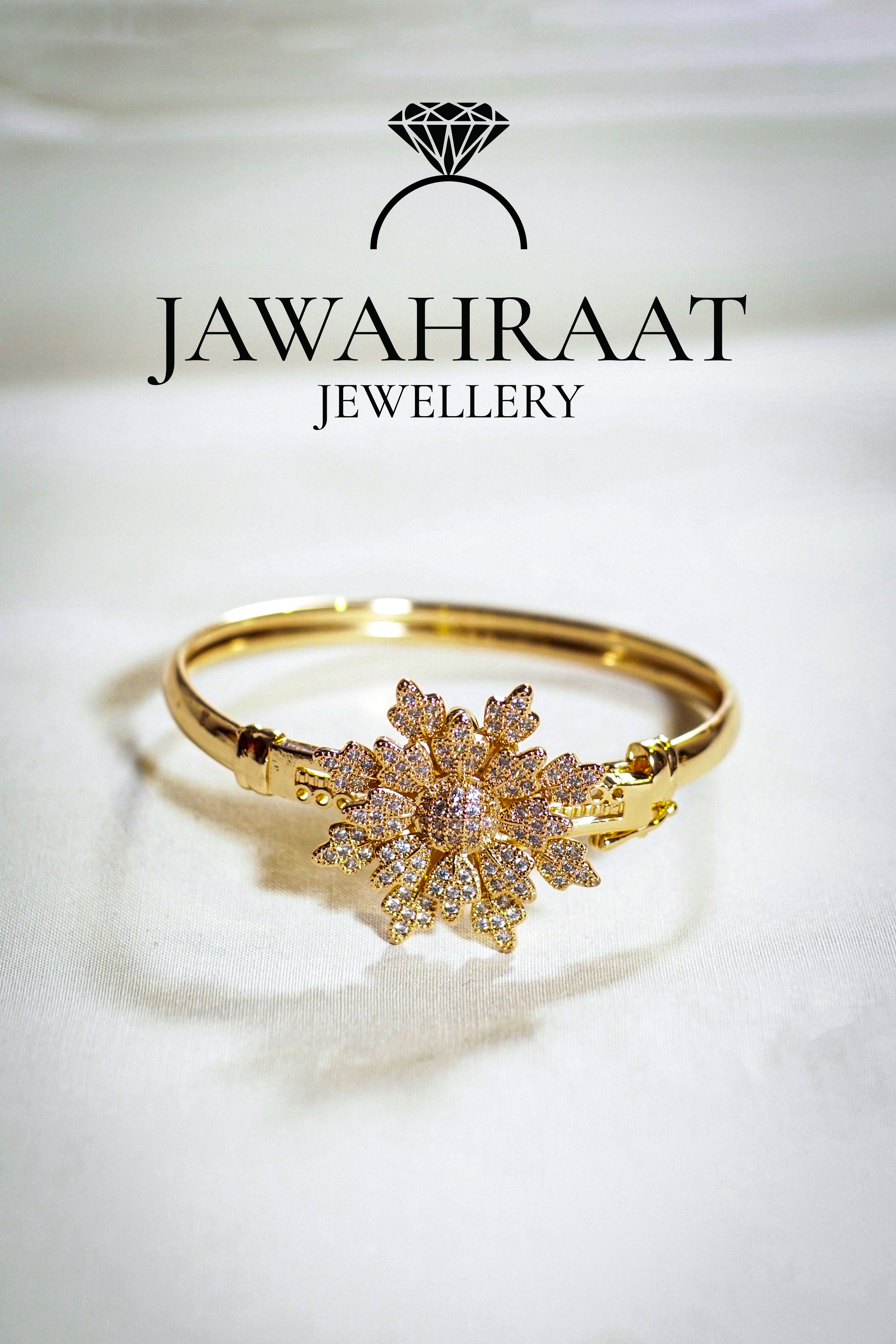 Intricate gold-toned bangle with floral detailing and white stones – festive wear accessory