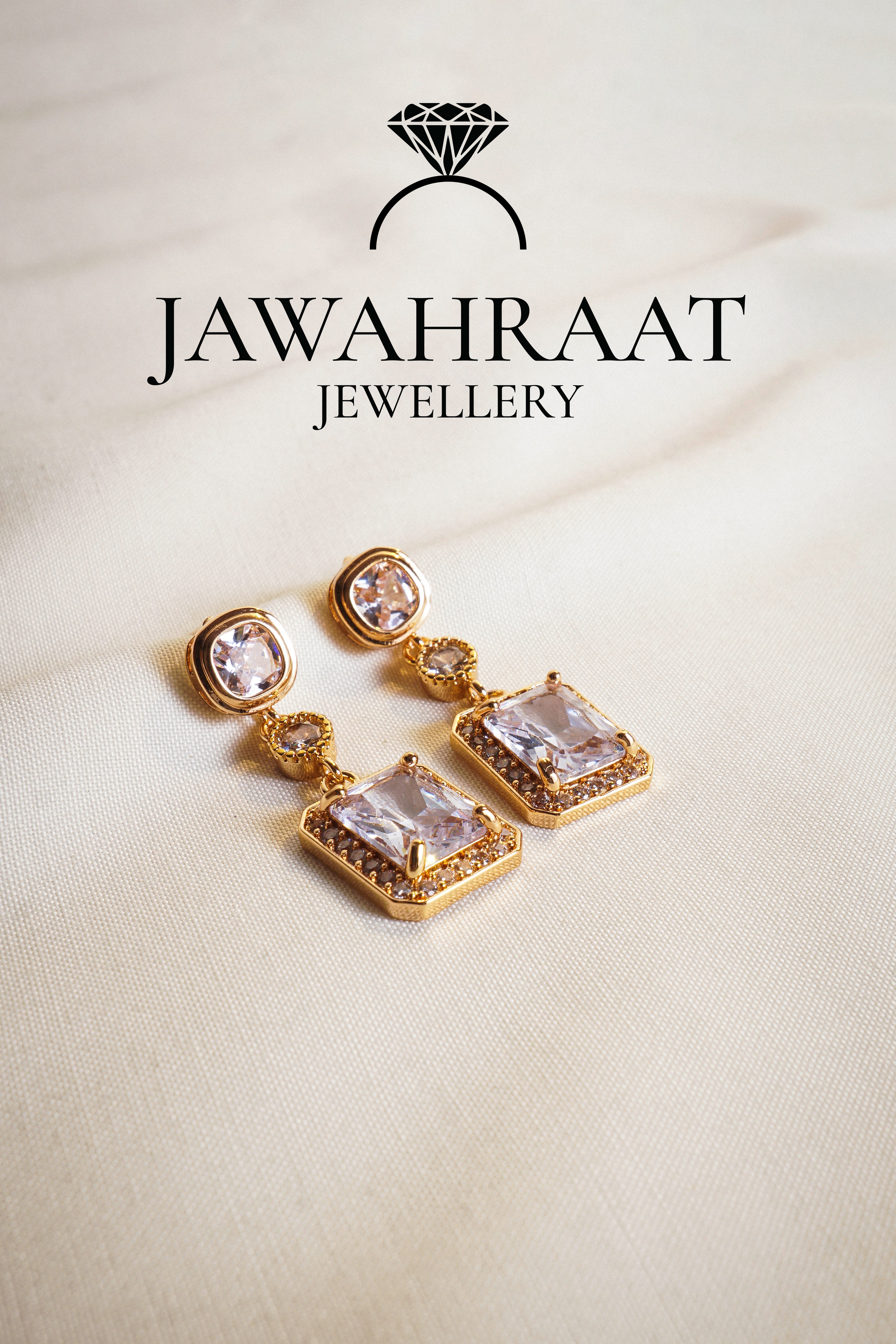 Front view of Crystal Cascade Earrings in gold tone by Jawahraat Jewellery – featuring a tiered design with square, round, and rectangular crystals, accented with pave details.


