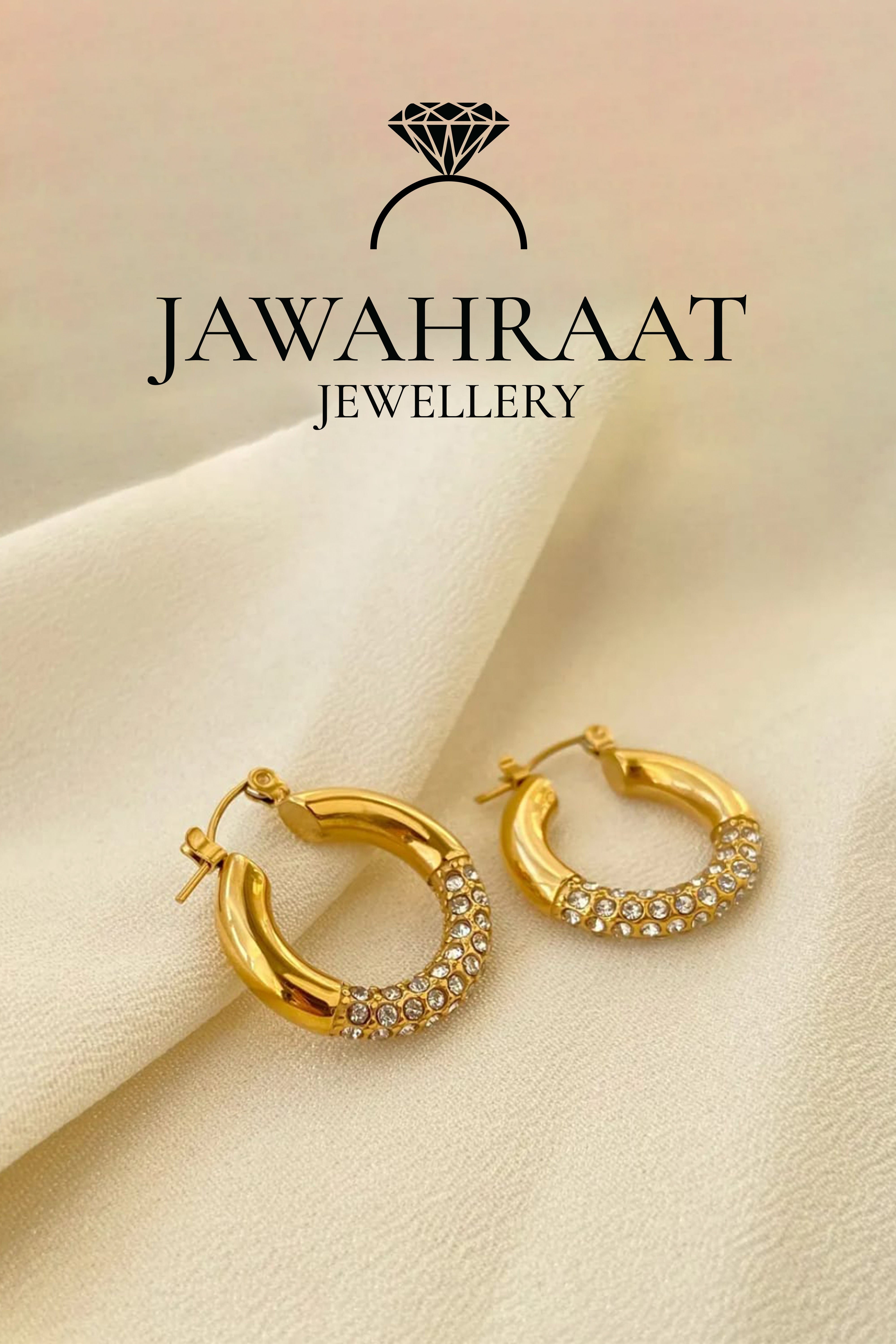 Gold-toned hoop earrings by Jawahraat Jewellery, crafted from stainless steel and embellished with clear crystals — a perfect blend of everyday elegance and subtle glamour.

