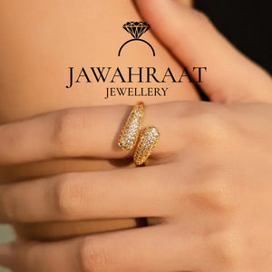 Gold-toned crystal twist ring by Jawahraat Jewellery, worn on a model’s finger, highlighting how the elegant twisted design sparkles when worn.

