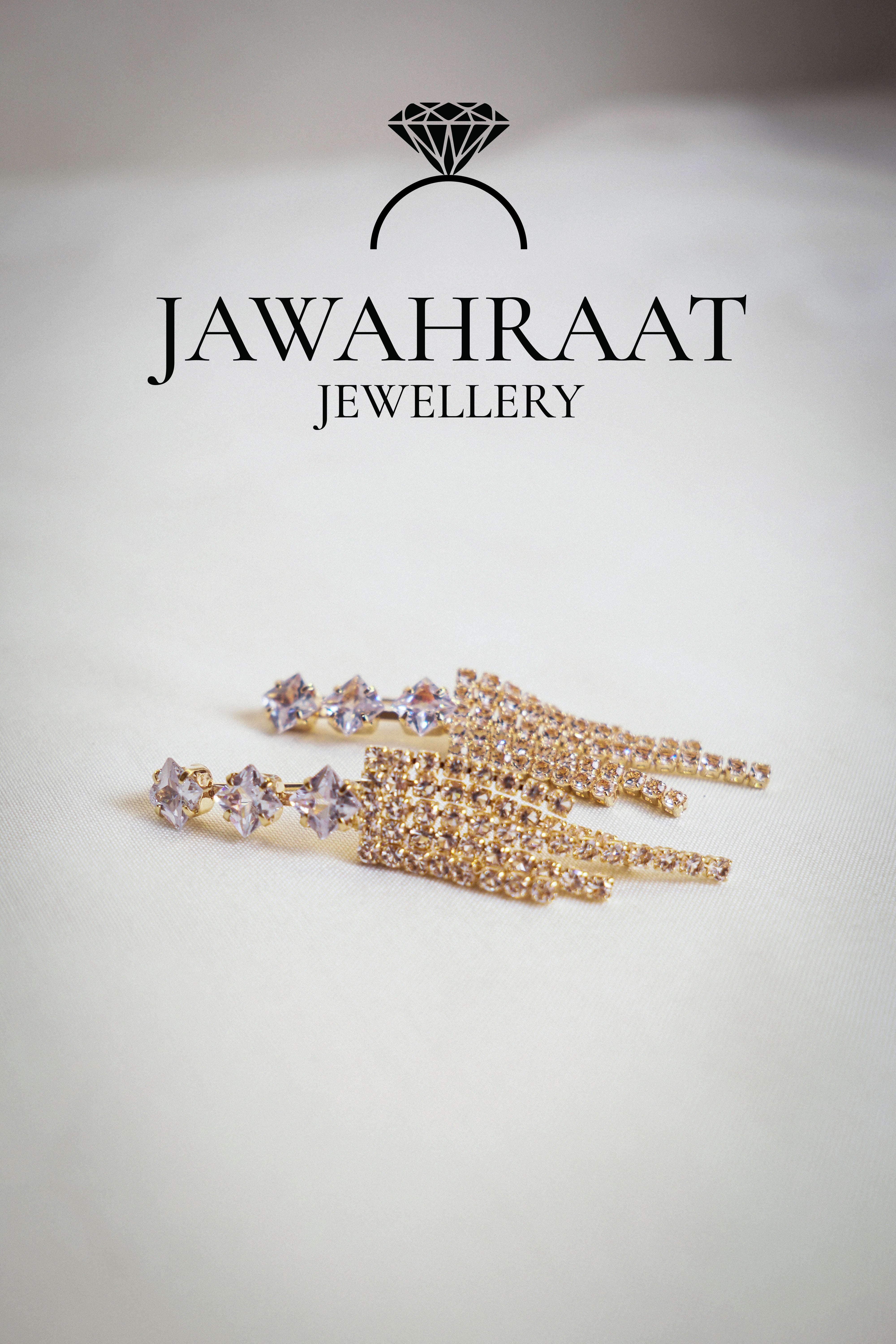 Front view of gold-tone multi-chain dangle earrings by Jawahraat Jewellery, featuring delicate hanging chains with sparkling rhinestone accents for a graceful, stylish look.


