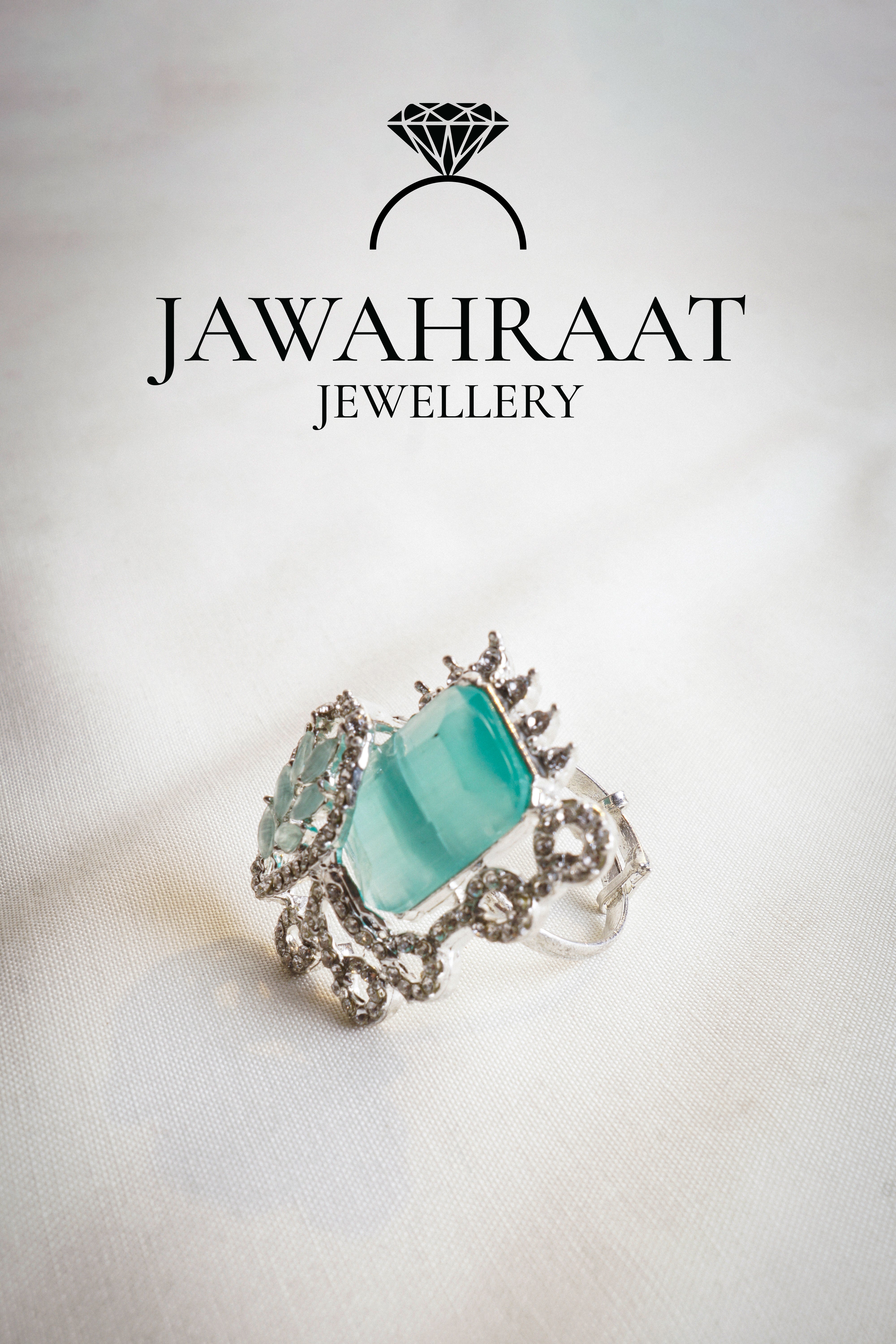 Side view of the Elara ring in aqua teal by Jawahraat Jewellery – silver-tone adjustable ring with rectangular crystal, pavé stones, and scrollwork detailing.


