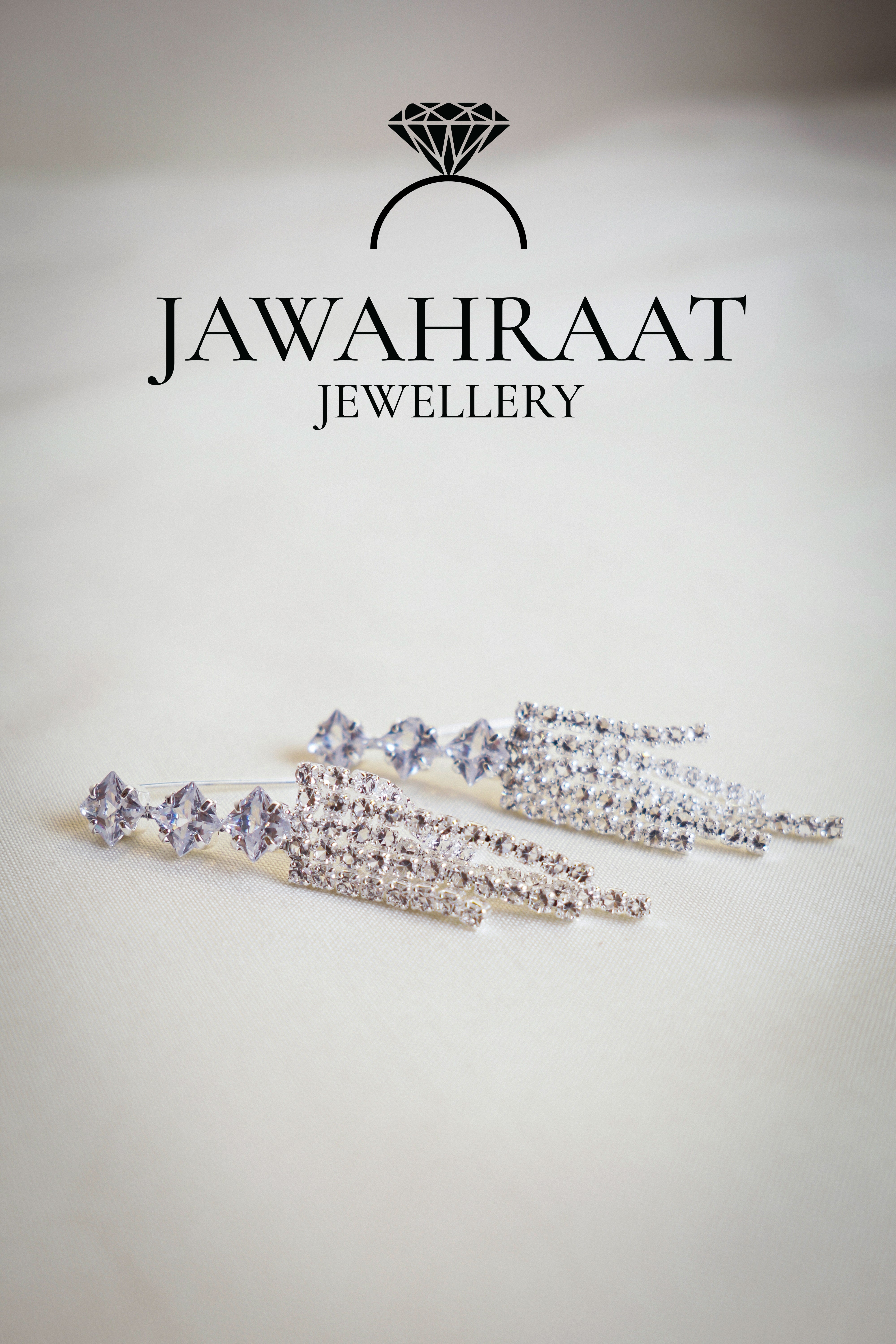 Front view of silver-tone multi-chain dangle earrings by Jawahraat Jewellery, designed with multiple fine chains and shimmering rhinestones for a modern, elegant effect.


