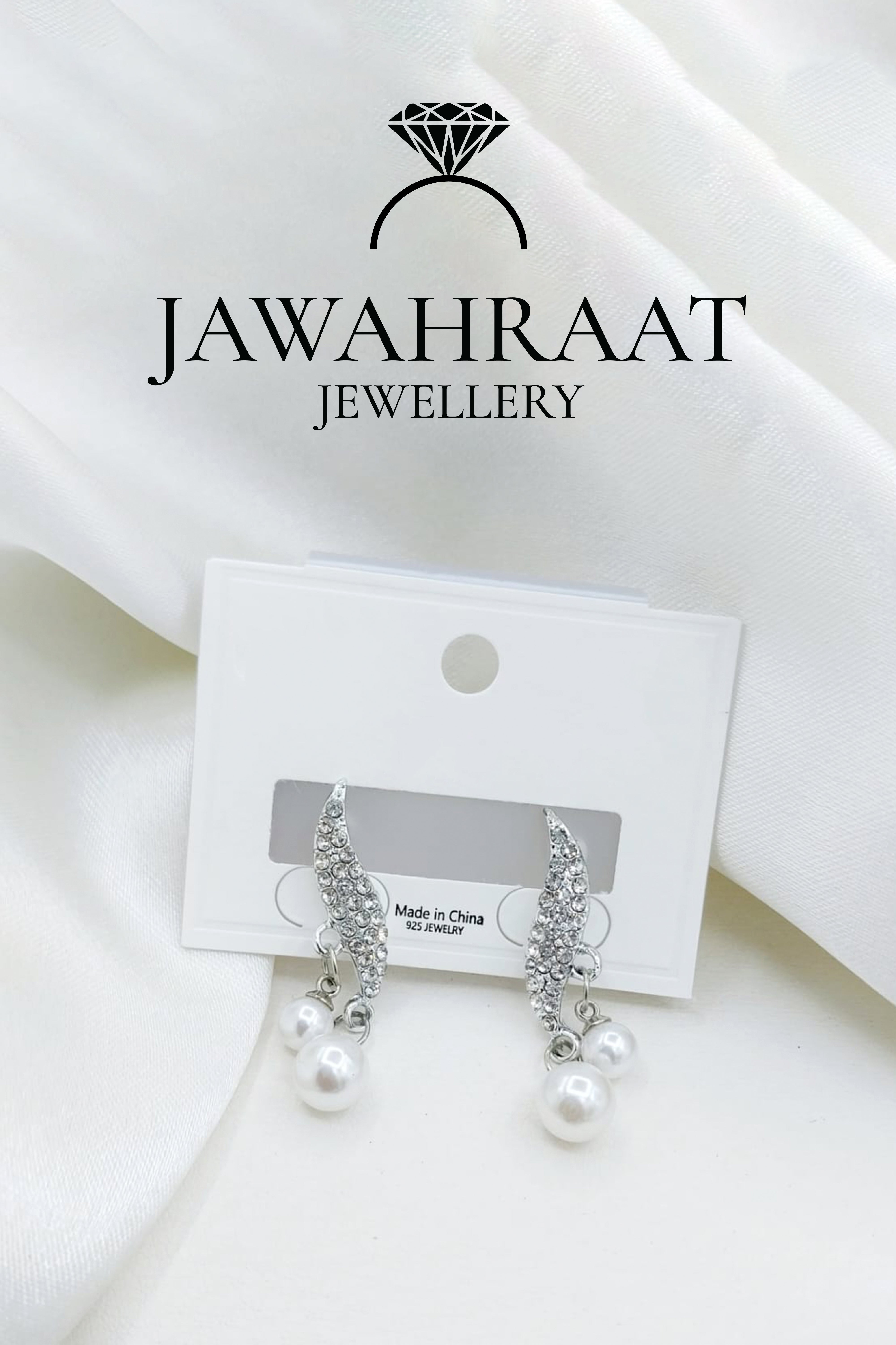 Elegant silver-toned drop earrings by Jawahraat Jewellery, featuring sparkling crystal accents and dangling faux pearls for a graceful and sophisticated look.

