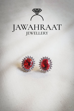 Close-up of matching silver earrings with red oval gemstones and sparkling white accents from the Red Oval Gem Set.

