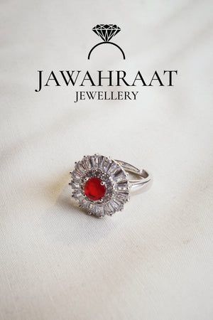 Adjustable silver ring with deep red teardrop stone and shimmering accents, perfect for special occasions