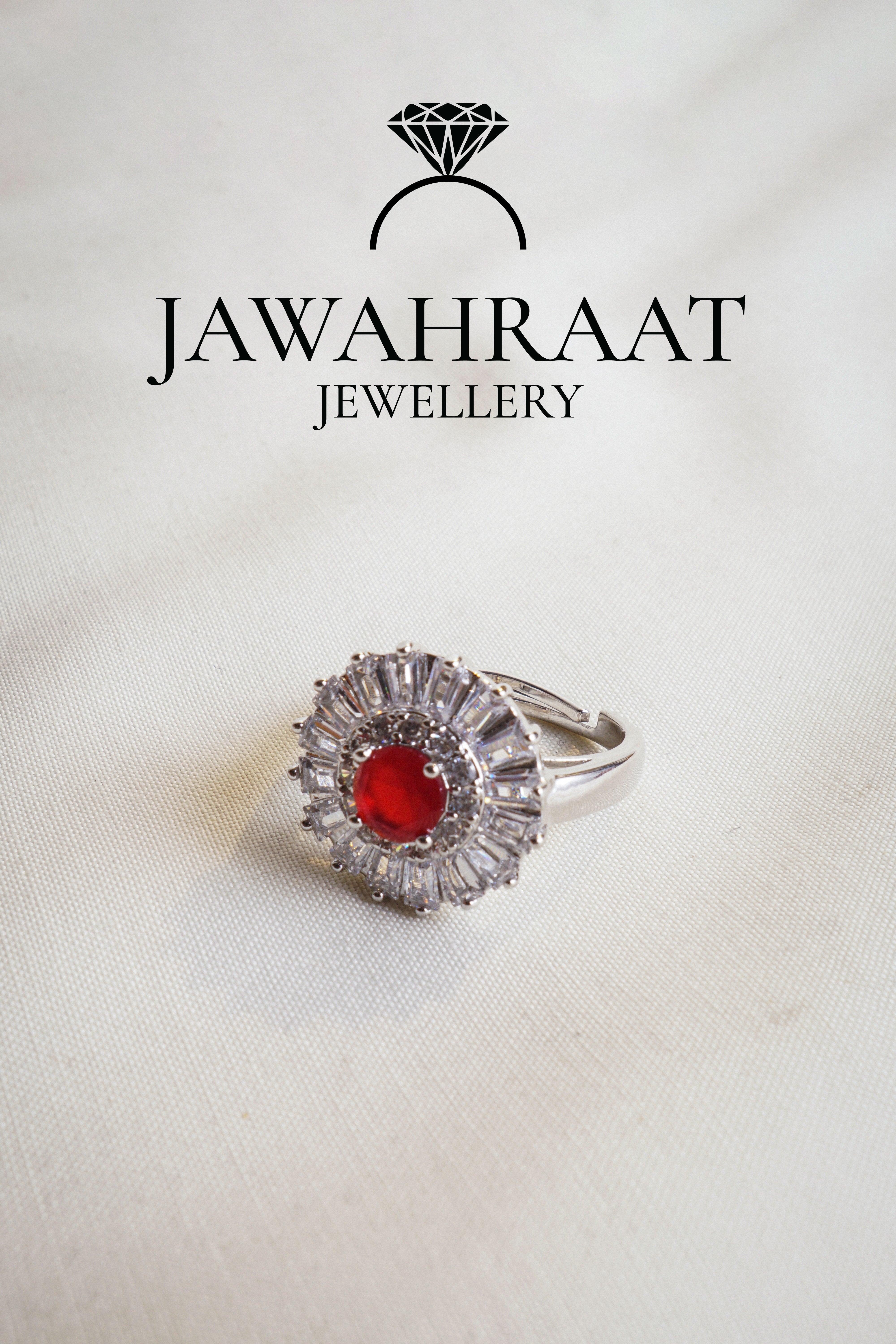 Adjustable silver ring with deep red teardrop stone and shimmering accents, perfect for special occasions