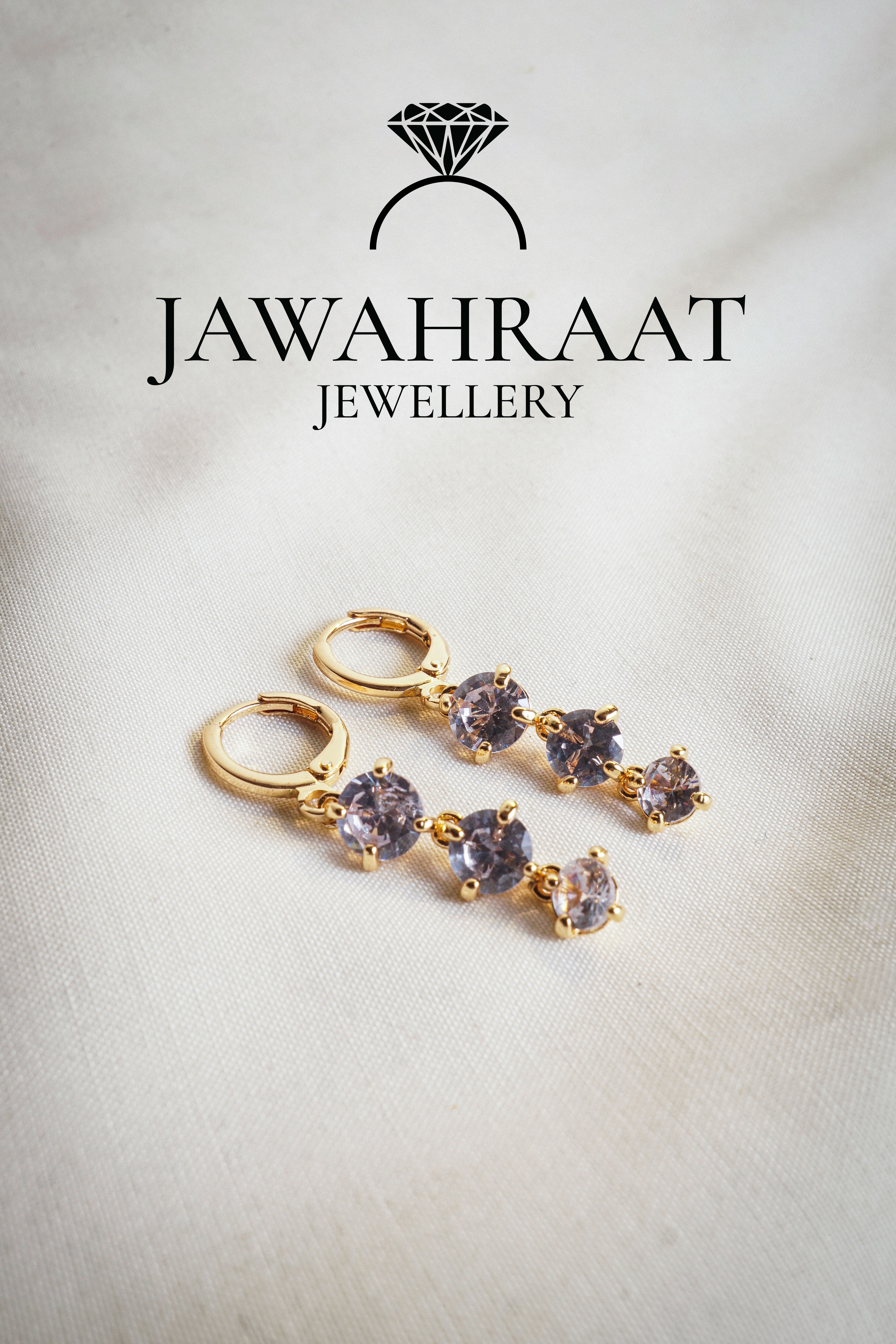 Close-up of gold-tone dangle earrings with radiant crystal clusters