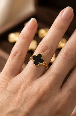 Gold plated clover leaf ring with black stone worn on finger