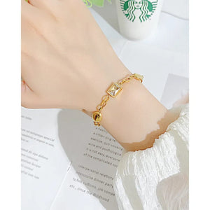 Gold link bracelet with crystal center worn on wrist