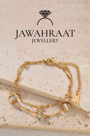 Jawahraat Jewellery gold-tone double-layer bracelet with baguette CZ barrel charms on marble