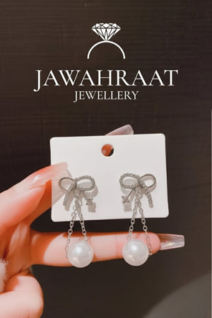 Silver bow pearl drop earrings with CZ crystals and faux pearl from Jawahraat Jewellery artificial jewellery