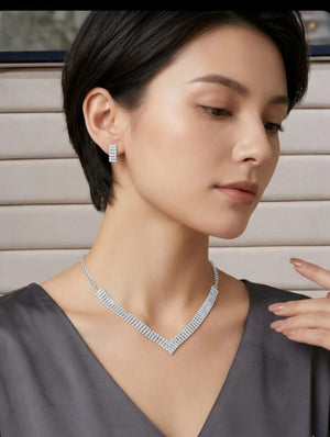 Woman wearing silver V shape rhinestone necklace with matching stud earrings