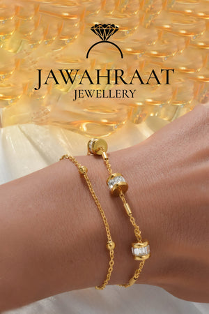 Woman wearing gold-tone double-layer CZ bracelet with sparkling baguette charms by Jawahraat Jewellery